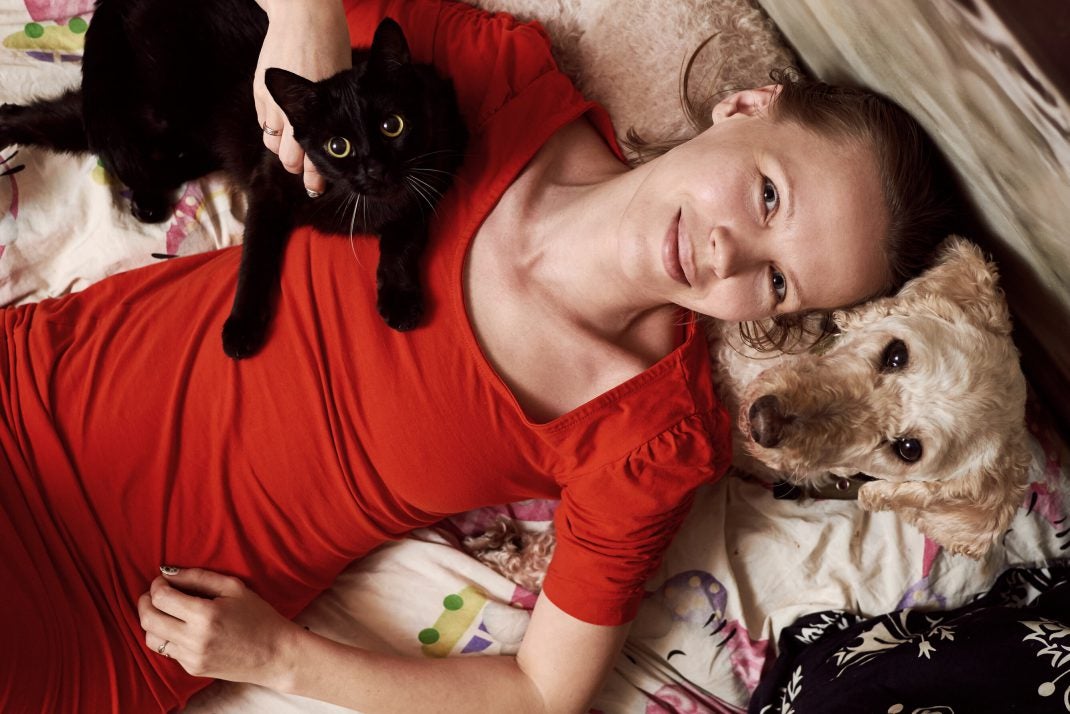 Woman in red shirt with dog and cat