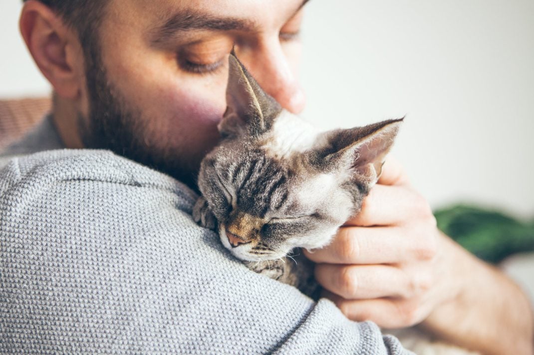 Man cuddling with cat